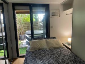 una camera da letto con un letto e una porta scorrevole in vetro di Charmante maison-chalet, vélos et jacuzzi ad Arcachon