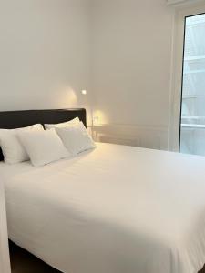 a white bed with white pillows and a window at Boulevard Lisbon Prime Suite in Lisbon