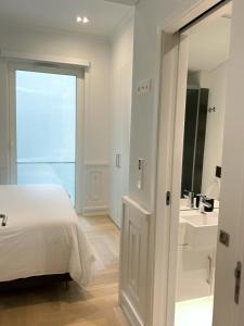 a bedroom with a bed and a bathroom with a sink at Boulevard Lisbon Prime Suite in Lisbon