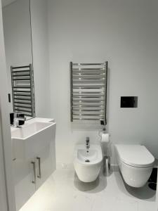 a white bathroom with a toilet and a sink at Boulevard Lisbon Prime Suite in Lisbon +7 photos