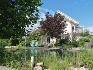 a house with a pond in front of it at Garden Paradise Bled Apartments - garden, pond and castle view in Bled