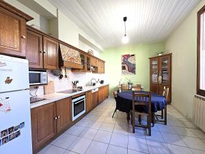 a kitchen with a table and a refrigerator at Charmante maison idéalement située - Eurythmie - 6 personnes - Jardin terrasse privés - Parking gratuit - 5 min à pied centre ville in Montauban
