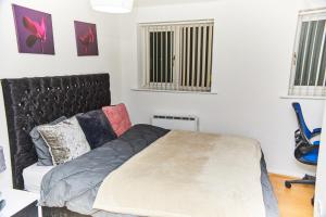 Un dormitorio con una cama y dos ventanas. en Emerald Apartments A star Proximity, en Londres