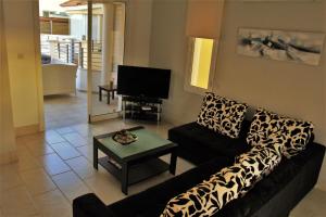 un salon avec un canapé et une télévision dans l'établissement Villa Marina, à Paphos