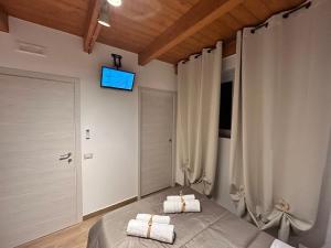 a bedroom with a bed with a television on the wall at La Dimora del Viandante in San Giorgio