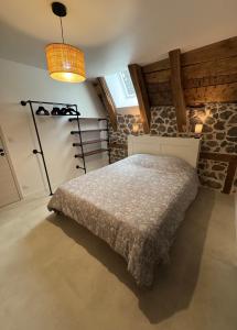 Un dormitorio con una cama y una lámpara. en La grange du pouget, en Polminhac 3 fotos más