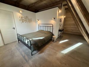 Un dormitorio con una cama en una habitación con escalera. en La grange du pouget, en Polminhac
