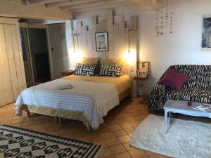 a bedroom with a bed and a couch at La grotte du pèlerin - Appartement semi-troglodyte in Saintes
