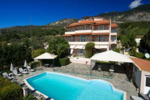 a large house with a swimming pool in front of it at Nostos in Mousata