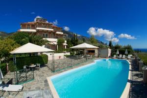 a hotel with a swimming pool in front of a building at Nostos in Mousata