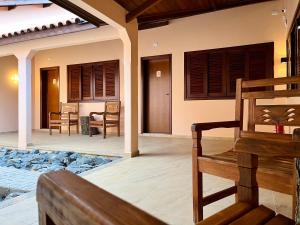 a porch of a house with chairs and a table at Pousada Essência do Vale in Cruzeiro