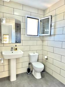 a bathroom with a toilet and a sink and a mirror at Castillo7 in Tarajalejo +9 photos