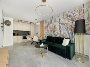 a living room with a green couch and a kitchen at Apartment in Dziwnów by River and Beach in Dziwnów