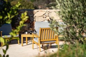 a wooden bench and a table and a stone wall at Villa Šjora - ''Autentic Dalmatian Stone Villa with Private Garden & BBQ'' in Vrboska