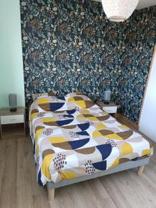 a bedroom with a bed with a colorful quilt at Hébergement le Mans in Le Mans +2 photos