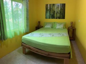 um quarto com uma cama grande num quarto amarelo em Green Queendom Farm and Lodging em Oracabessa