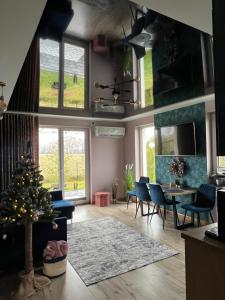 salon z choinką świąteczną, stołem i krzesłami w obiekcie Domki całoroczne Zacisze Bałtów w Ostrowcu Świętokrzyskim