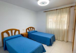 a bedroom with two beds and a window at Euromar II - TEPINSA Alquiler de Apartamentos in Torreblanca