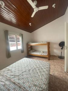 una camera da letto con un letto e un ventilatore a soffitto di Casa Tucano a São Sebastião