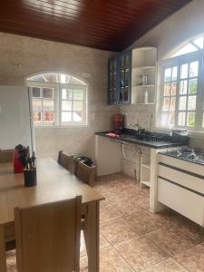 una cucina con un tavolo e un piano di lavoro di Casa Tucano a São Sebastião