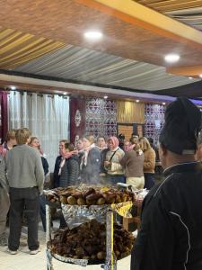 a group of people standing around a table with food at Orbit camp in Wadi Rum