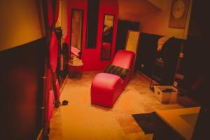 a living room with a red chair and a table at Osez! Le fruit défendu Loveroom Carpentras in Carpentras