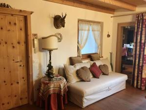 ein Wohnzimmer mit einer weißen Couch mit Kissen in der Unterkunft Luxury panoramic apartment Plan de Corones in Welsberg-Taisten