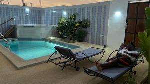 a woman laying in a chair next to a swimming pool at Villa 3 patios in Somone