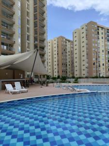 a swimming pool with a tent and some buildings at Apartamento en Villeta Hermoso in Villeta