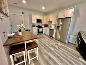 a kitchen with a wooden table and stainless steel refrigerator at The Stylish Suite - 1BR with Free Parking in Paterson +12 photos