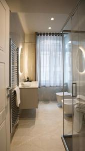 a bathroom with a tub and a sink and a toilet at The Corner Bergamo Elegant Apartments in Bergamo +40 photos