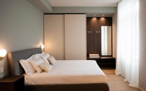 a bedroom with a large bed with white pillows at The Corner Bergamo Elegant Apartments in Bergamo