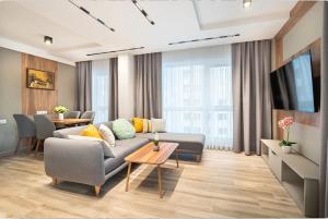 a living room with a couch and a tv at Апартхотел Сенатор Пловдив Self check-in in Plovdiv