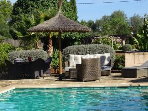 a pool with chairs and an umbrella and a table at Finca La Vida Apartment Boungavilla in Llucmajor +16 photos