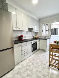 a kitchen with white cabinets and a refrigerator at Apartamentos de la Casa Ducal in Gandía