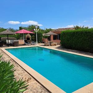 a large blue swimming pool in front of a house at Finca La Vida Apartment Boungavilla in Llucmajor