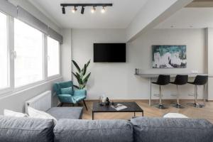 a living room with a couch and chairs and a tv at Ladadika Urban Apartment Two Bedroom in Thessaloniki