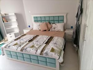 a bedroom with a large bed with a blue headboard at Majaz3 in Sharjah