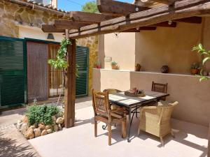 a patio with a table and chairs on a patio at Finca La Vida Apartment Boungavilla in Llucmajor