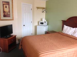 um quarto de hotel com uma cama e um micro-ondas em Relax Inn em Webster