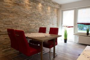 a dining room with a wooden table and red chairs at Olivia in Norden