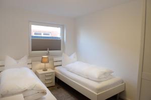 a bedroom with two beds and a window at Deichnähe - G in Norddeich