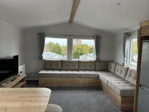 a living room with a couch and a tv at 30, Sunset Terrace in Lytchett Minster