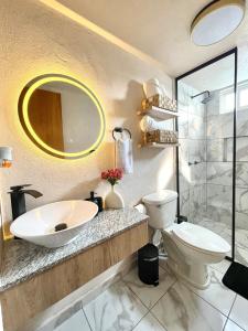 a bathroom with a sink and a toilet and a mirror at Hermoso Departamento, WiFi, terraza vista al Lago de Pátzcuaro, elevador, free parking in Pátzcuaro +32 photos
