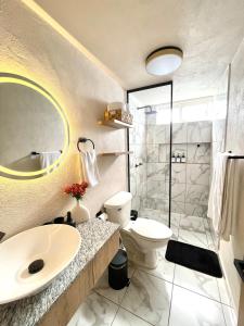 a bathroom with a sink and a toilet and a shower at Hermoso Departamento, WiFi, terraza vista al Lago de Pátzcuaro, elevador, free parking in Pátzcuaro