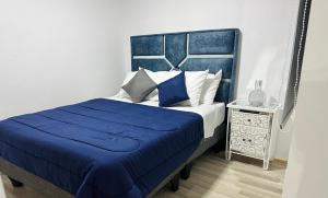 a bedroom with a blue and white bed and a night stand at Departamento Hermanos Maristas in Los Andes