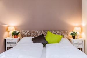 a bedroom with a white bed with green pillows at Wildgrün Mini Lodge 8a in Pfronten