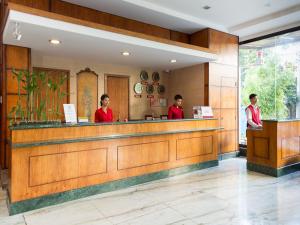 MJ Hotel and Suites في مدينة سيبو: شخصين واقفين عند كاونتر مطعم