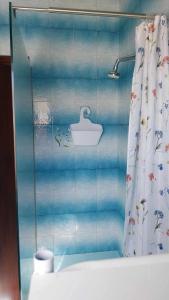 a bathroom with a shower curtain and a sink at Sunny large terrace studio apartment WiFi Airconditioners BBQ in Mellieħa