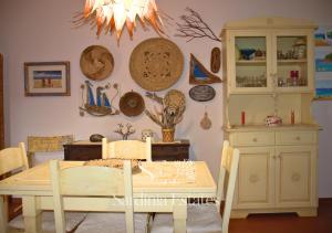 una sala da pranzo con tavolo e alcuni piatti appesi al muro di Suite Fronte Mare - Brezza Dorata a Porto Rotondo Altre 39 foto